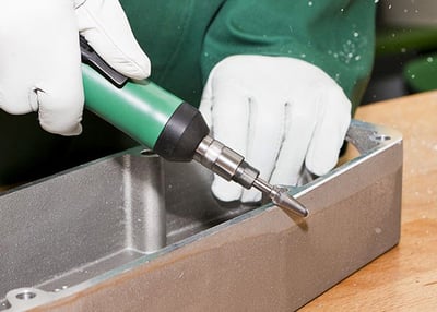 Deburring the edge of metal to reduce the risk of filiform corrosion