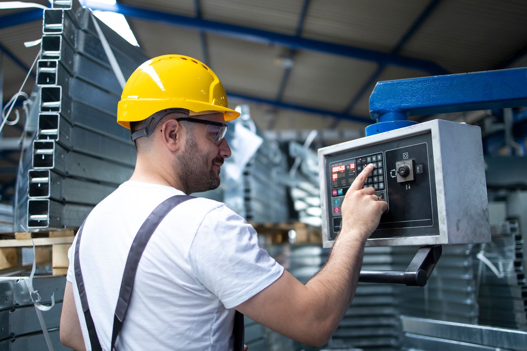 factory-worker-operating-industrial-machine-setting-parameters-computer